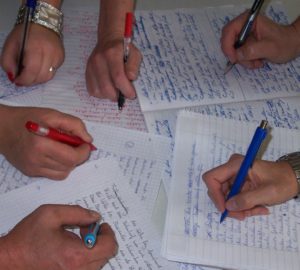 Viele hände mit Stiften und Texten in einem Kreativ Schreiben Kurs